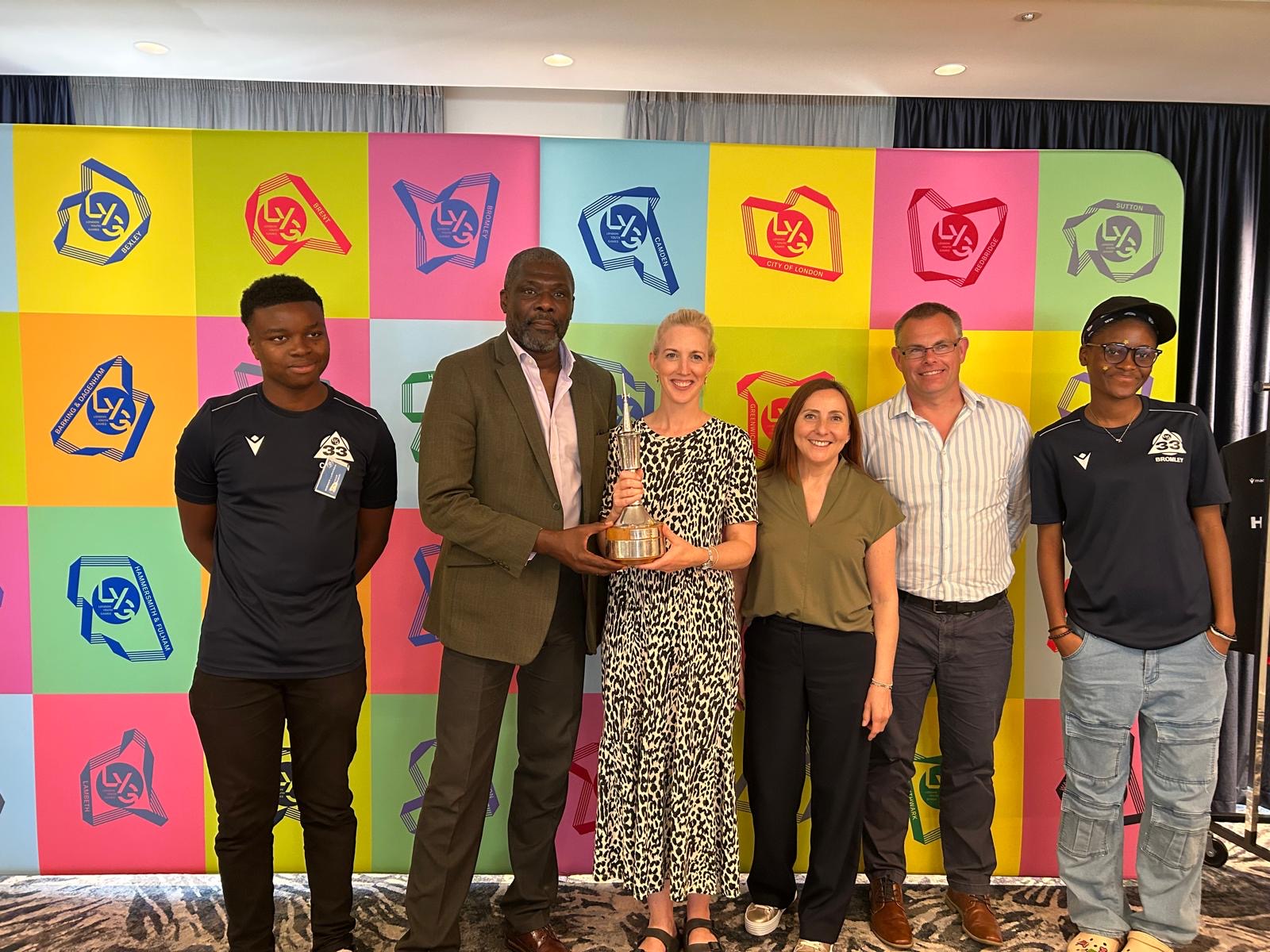 the Mytime Team accepting the trophy from Prof. Geoff Thompson MBE Chair of LYG alongside Bromley LYG rep, Aiyanna Lyttle.